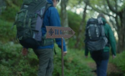 Folk på tur passerer et skilt med teksten "Gapahuk". Foto