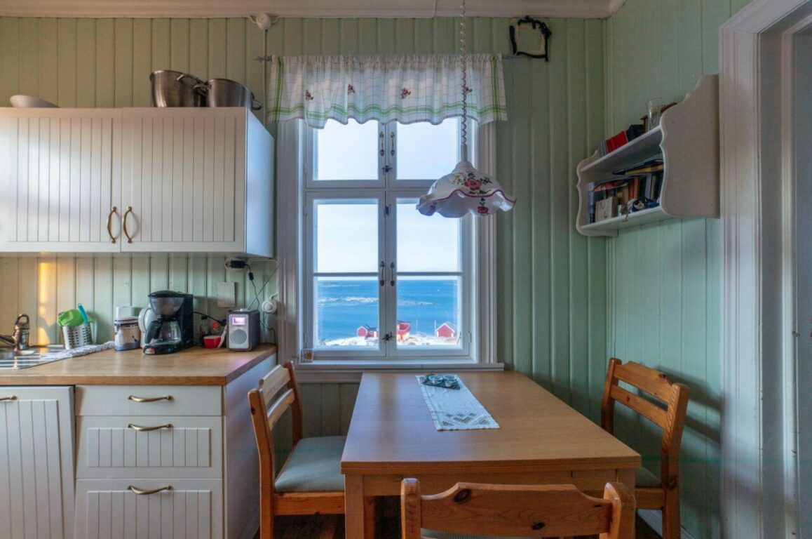 Kjøkken med spiseplass og utsikt utover havet